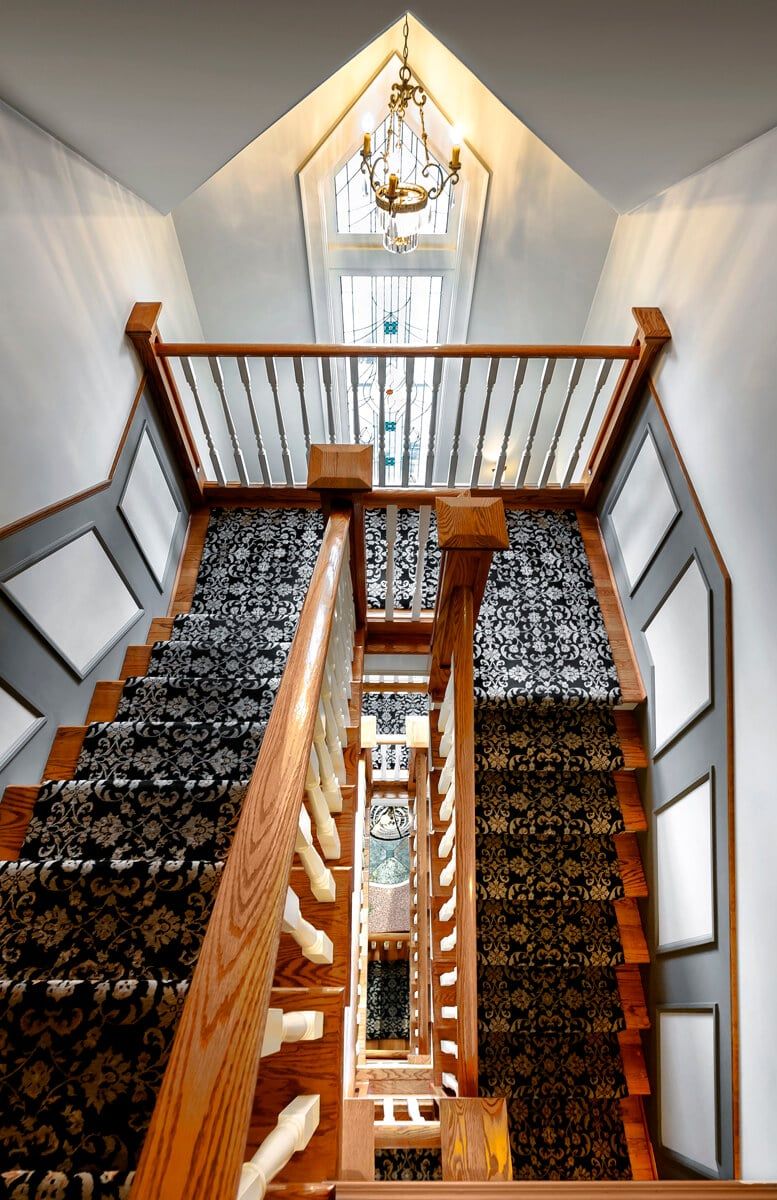 A staircase with a carpeted staircase leading up to the second floor