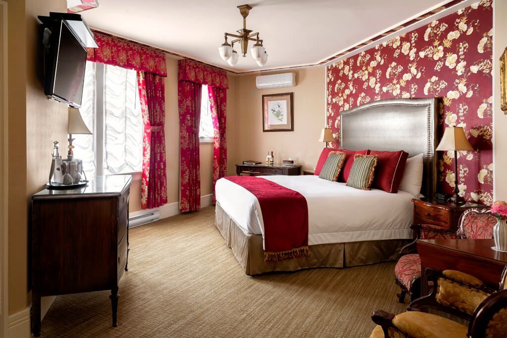 A hotel room with a king size bed and a television