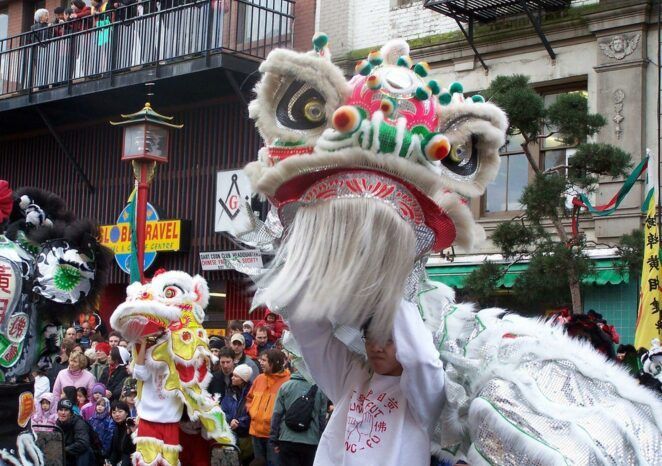 A man in a lion costume stands in front of a crowd