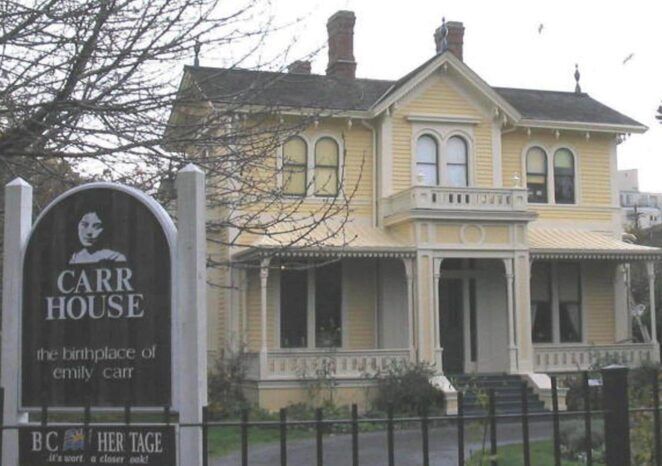 A large yellow house with a sign that says carr house