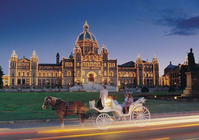 A horse drawn carriage is driving past a large building