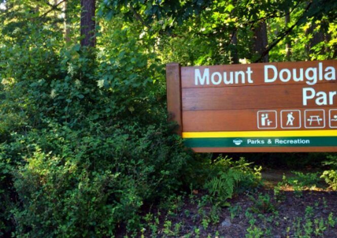 A sign for mount douglas park is surrounded by trees