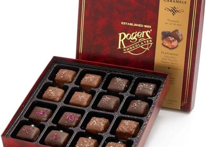 A box of rogers chocolates is open and filled with chocolates