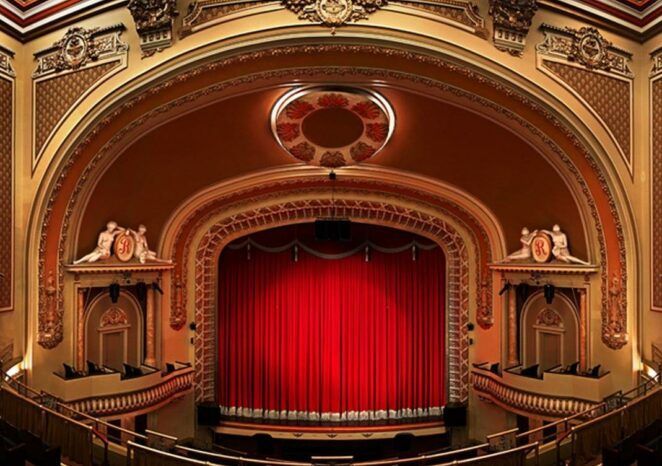 The inside of a theater with a red curtain