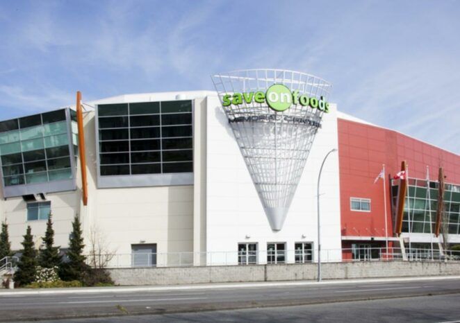 A large building with a green sign that says save on food