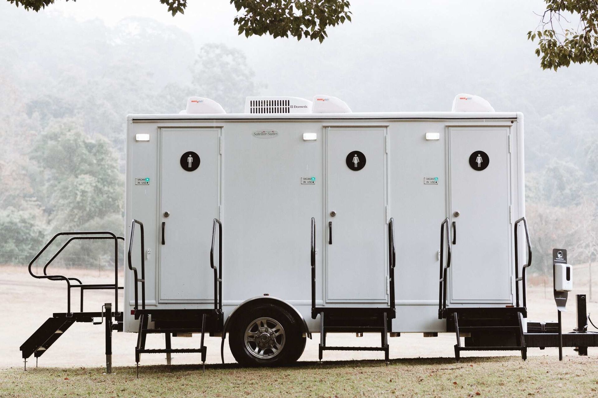 A Restroom With Stairs Attached to It is Parked in a Field — Absoloo Hire Pty Ltd in Forster, NSW