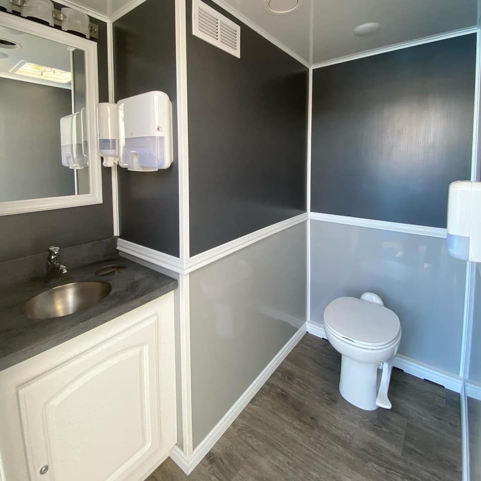 A Bathroom With a Toilet, Sink and Mirror — Absoloo Hire Pty Ltd in Forster, NSW