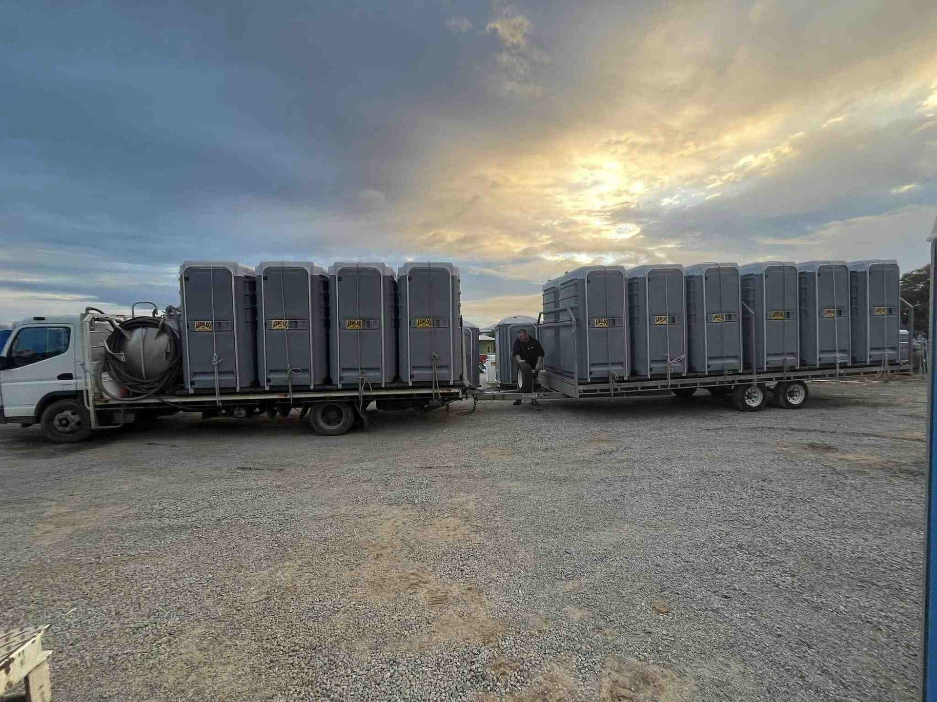 A Truck is Carrying a Trailer Full of Portable Toilets — Absoloo Hire Pty Ltd in Morisset, NSW