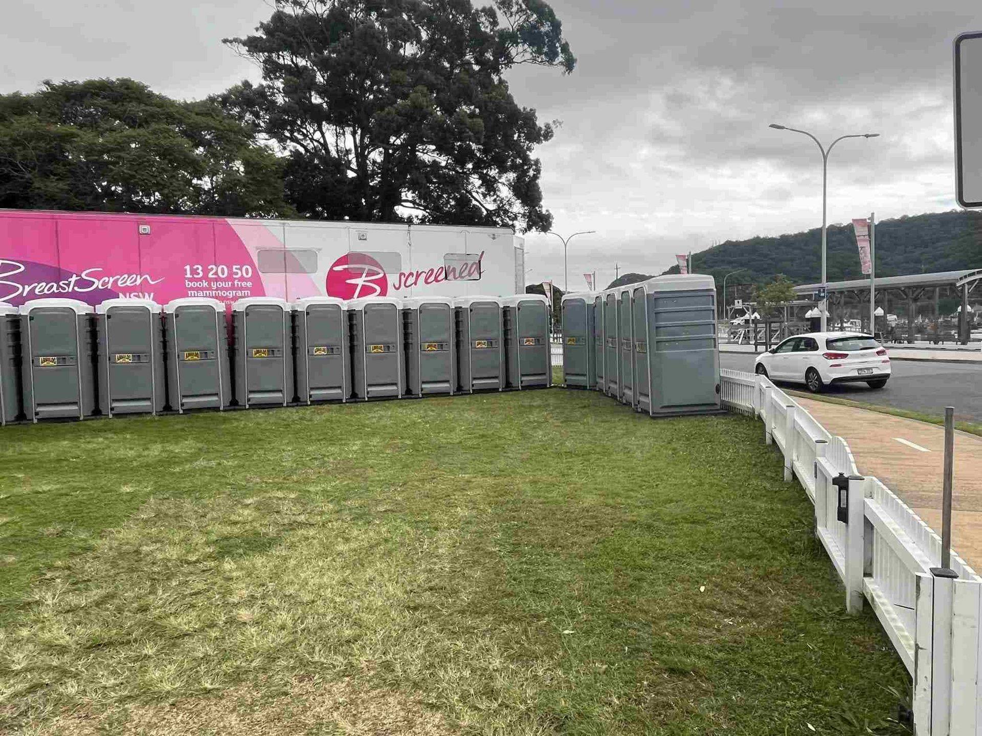 A Row of Portable Toilets Are Lined Up on the Side of the Road — Absoloo Hire Pty Ltd in Port Macquarie, NSW
