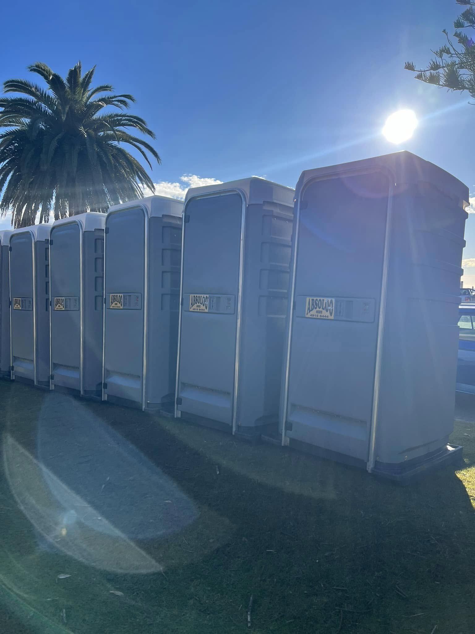 A Row of Portable Toilets Are Lined Up Next to Each Other — Absoloo Hire Pty Ltd in Port Macquarie, NSW