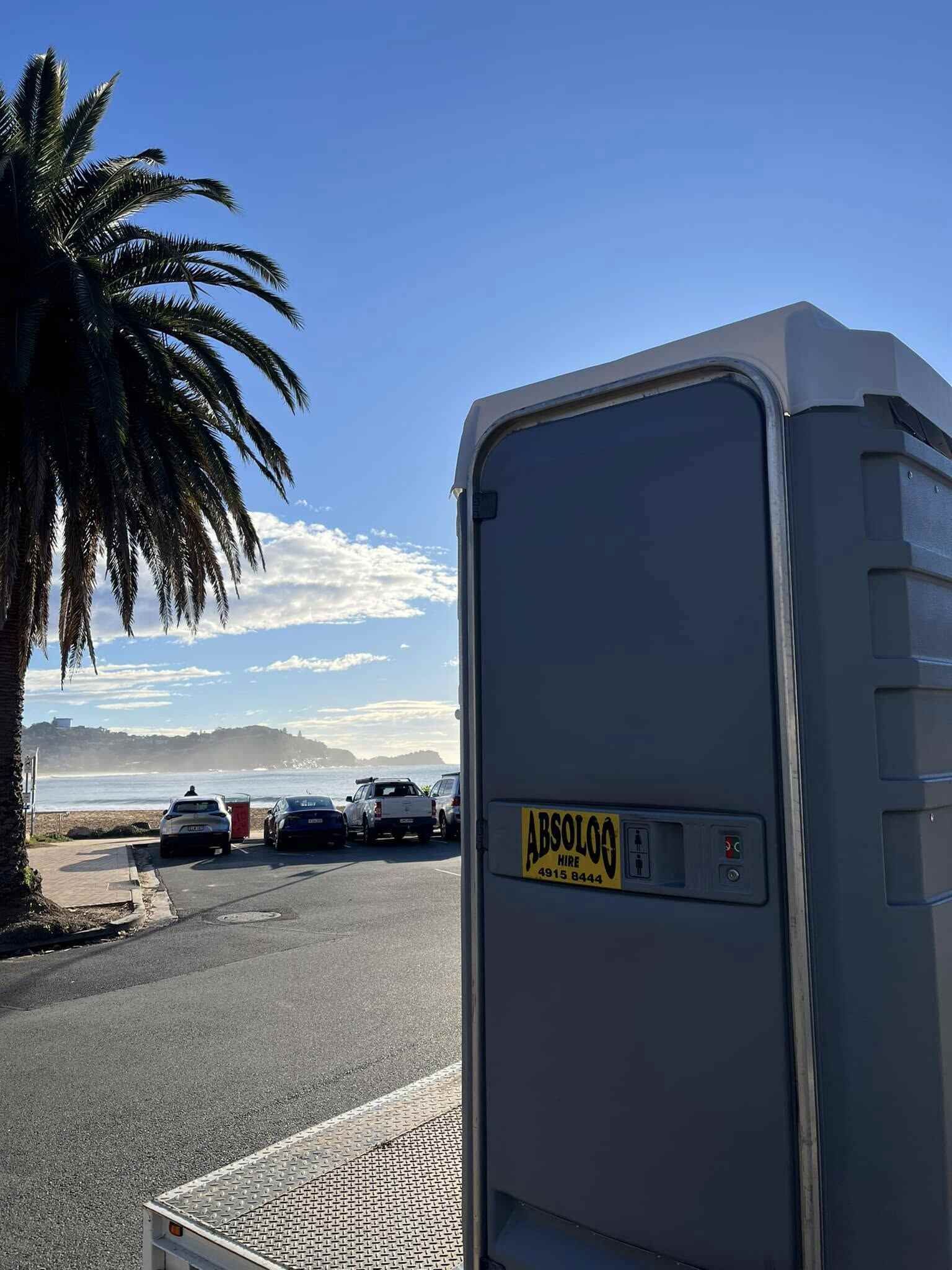 A Portable Toilet is Parked on the Side of the Road — Absoloo Hire Pty Ltd in Coffs Harbour, NSW
