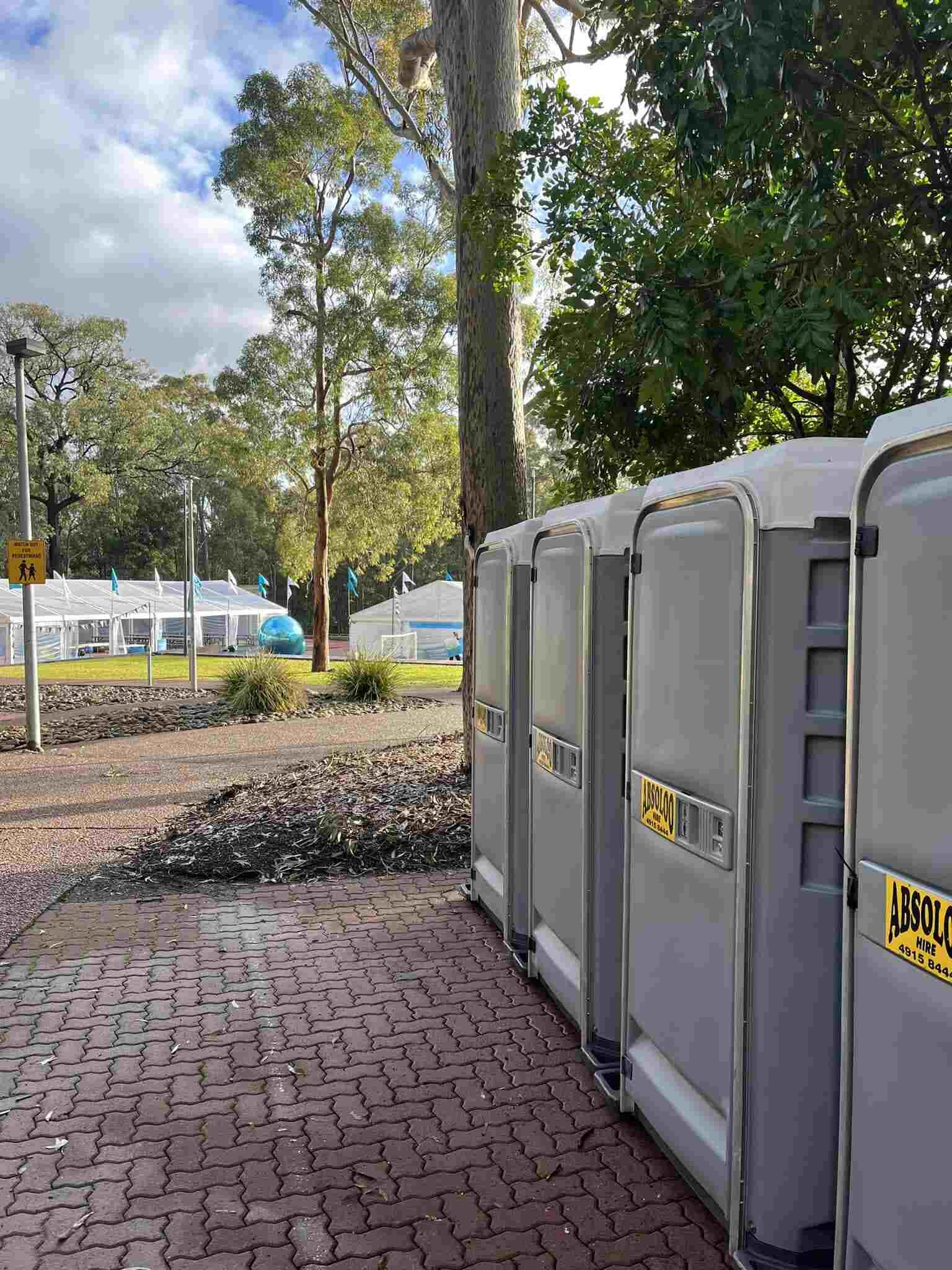 A Row of Portable Toilets Are Lined Up on a Brick Sidewalk — Absoloo Hire Pty Ltd in Forster, NSW