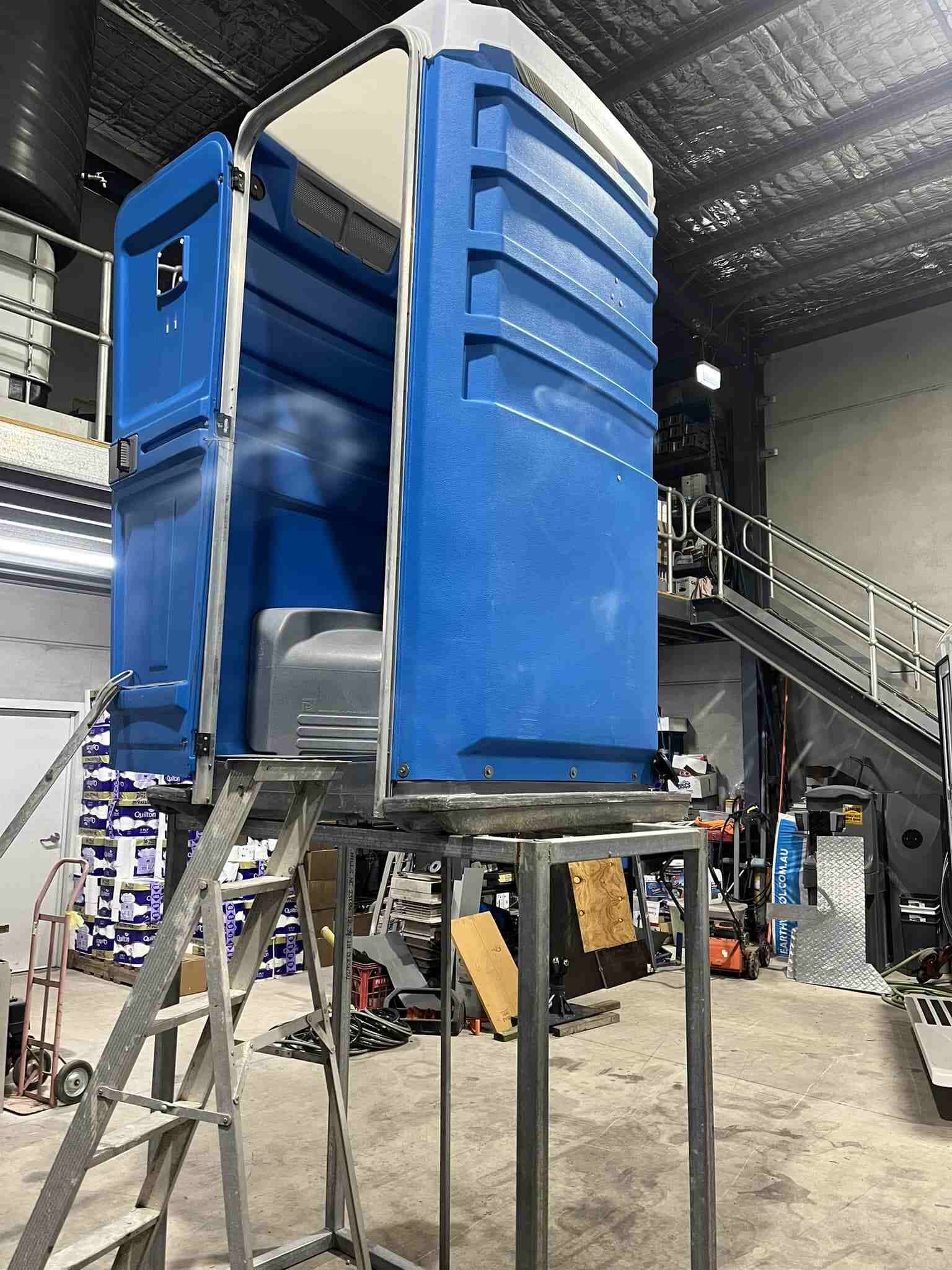 A Portable Toilet is Sitting on Top in a Warehouse — Absoloo Hire Pty Ltd in Morisset, NSW