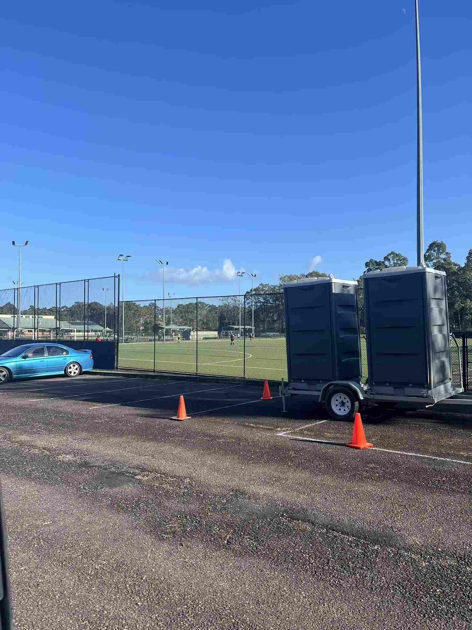 Two Portable Toilets Are Parked on a Trailer in a Parking Lot — Absoloo Hire Pty Ltd in Coffs Harbour, NSW