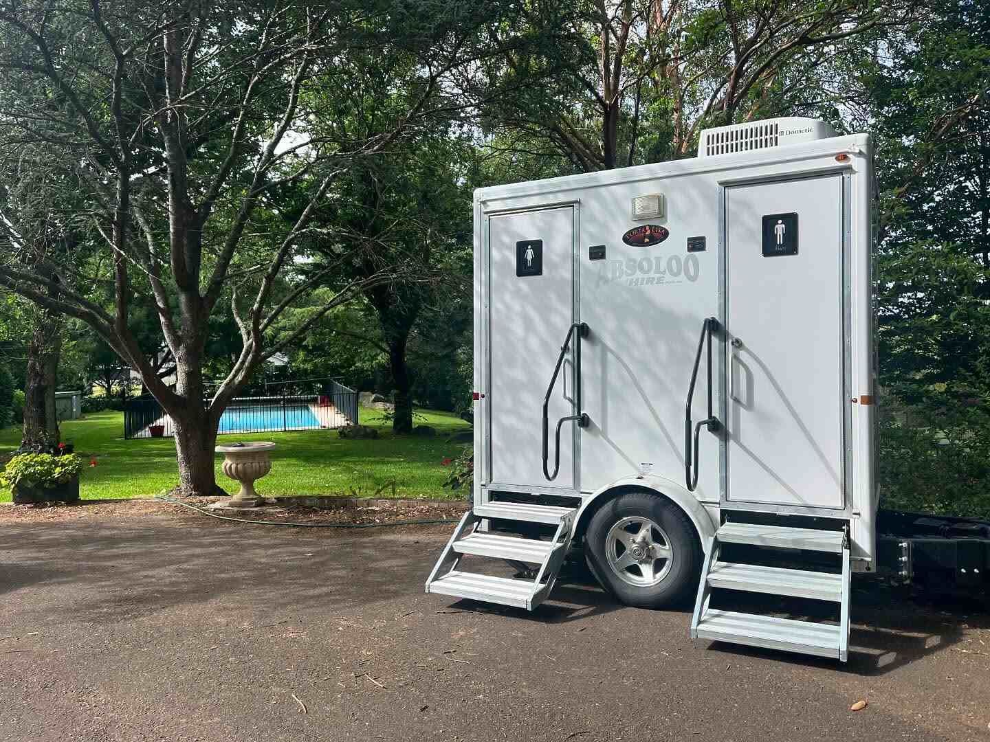 A Trailer With Two Toilets is Parked in a Parking Lot — Absoloo Hire Pty Ltd in Port Macquarie, NSW