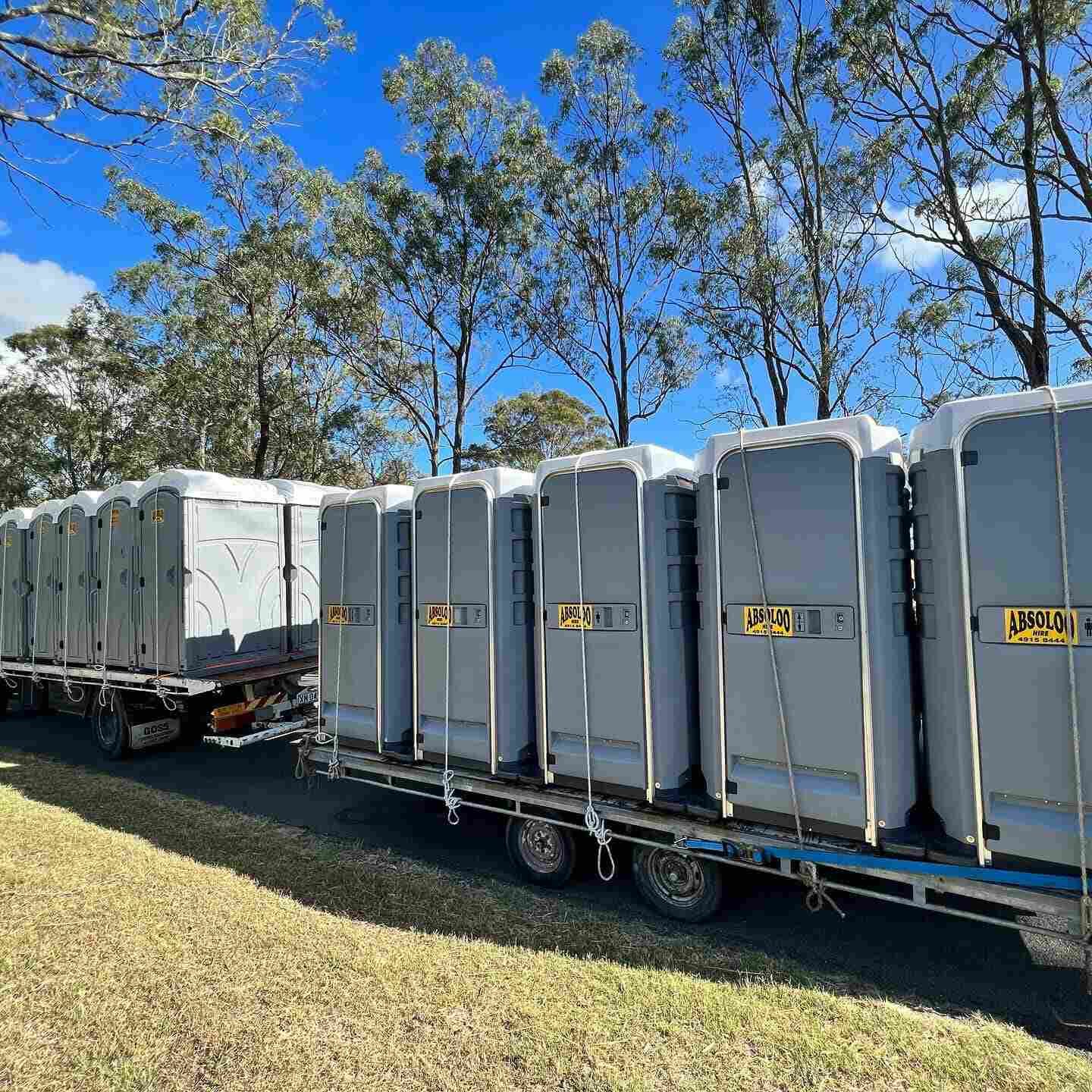 A Row of Portable Toilets Are Sitting on Top of a Trailer — Absoloo Hire Pty Ltd in Newcastle, NSW