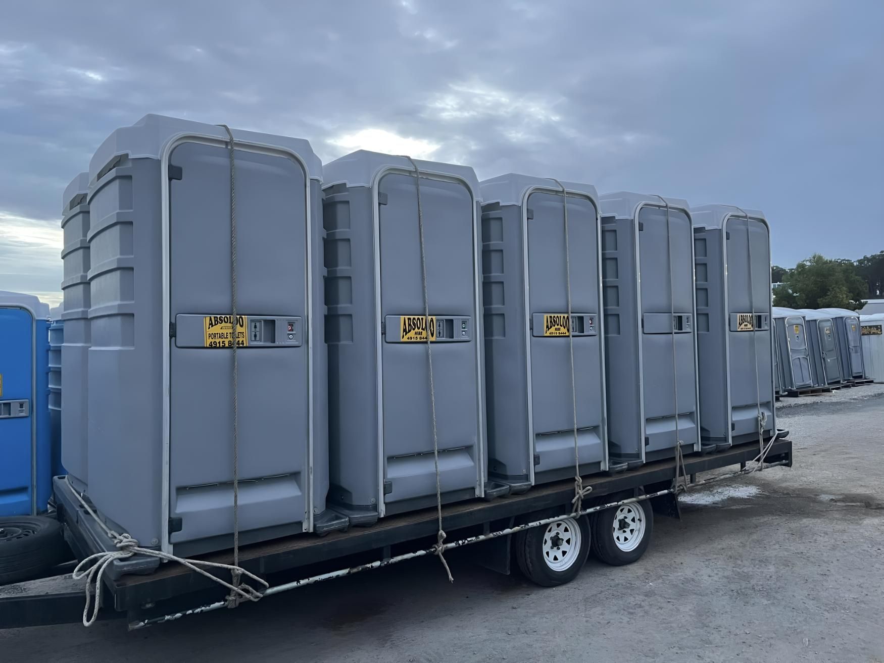 A Trailer Filled With Portable Toilets is Parked in a Parking Lot — Absoloo Hire Pty Ltd In Morisset, NSW