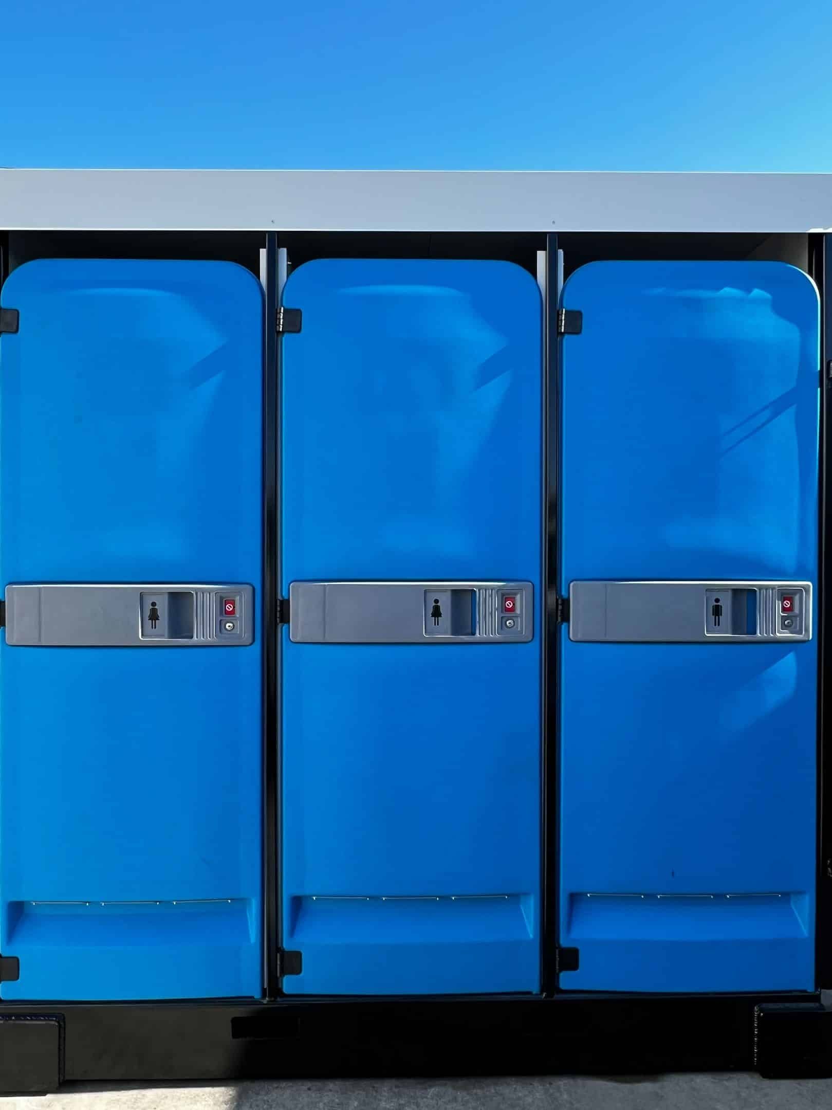 Three Portable Toilets Are Lined Up Next to Each Other — Absoloo Hire Pty Ltd in Port Macquarie, NSW