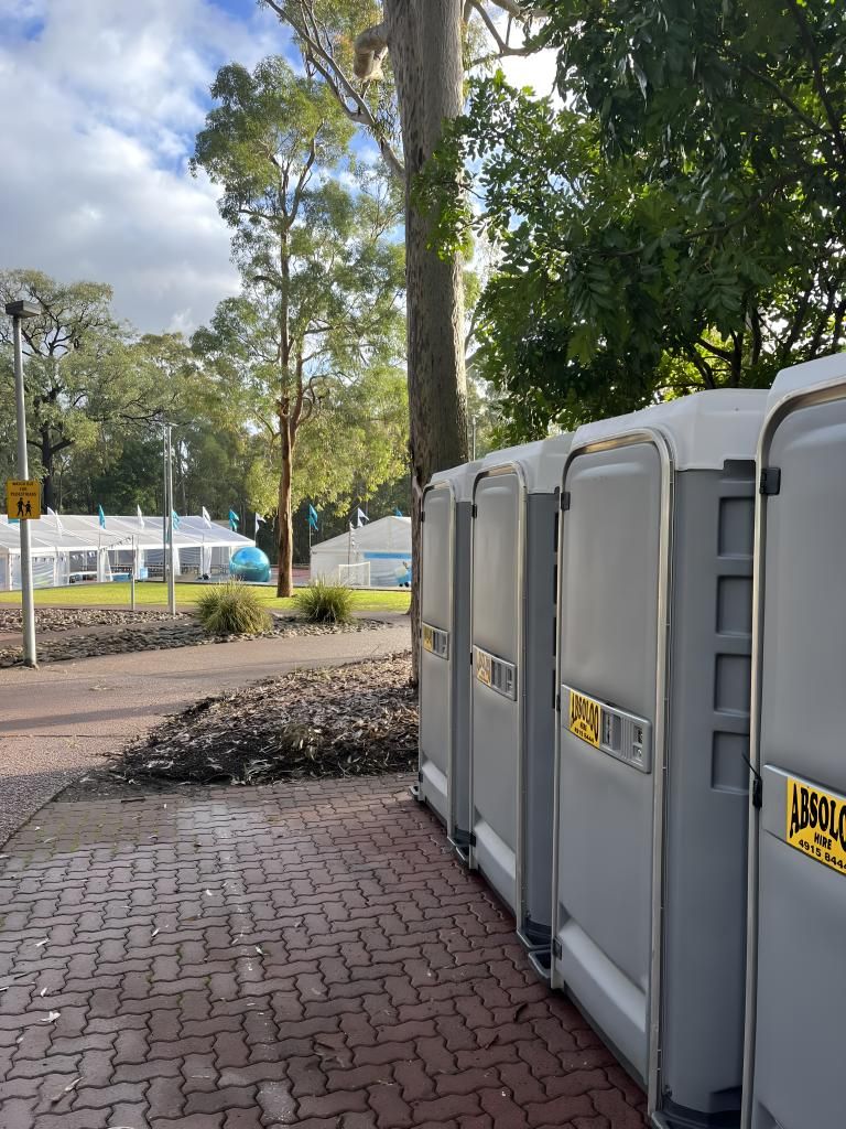 A Row of Portable Toilets Are Lined Up on a Brick Sidewalk. — Absoloo Hire Pty Ltd In Morisset, NSW
