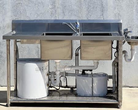 A Stainless Steel Kitchen Sink With Two Sinks and a Faucet — Absoloo Hire Pty Ltd in Hunter Valley, NSW
