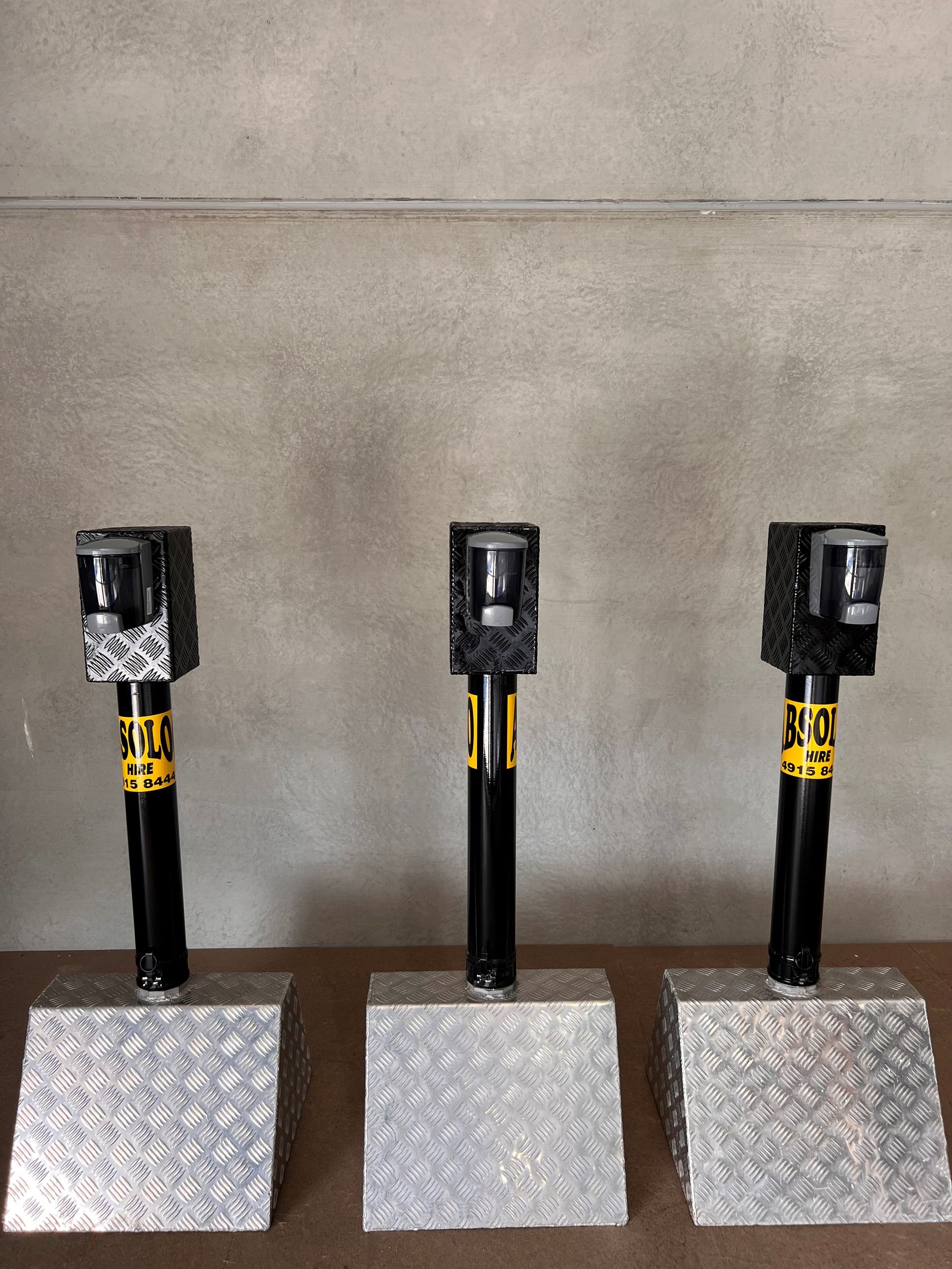 Three Metal Poles Are Sitting on Metal Blocks on a Table — Absoloo Hire Pty Ltd In Morisset, NSW