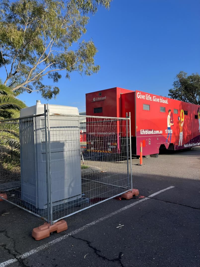 A Red Trailer is Parked in a Parking Lot Next to a Fence — Absoloo Hire Pty Ltd In Morisset, NSW