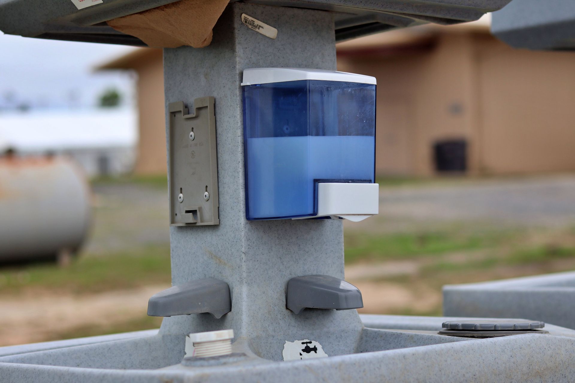 A Row of Concrete Sinks With Soap Dispensers on the Wall — Absoloo Hire Pty Ltd in Coffs Harbour, NSW