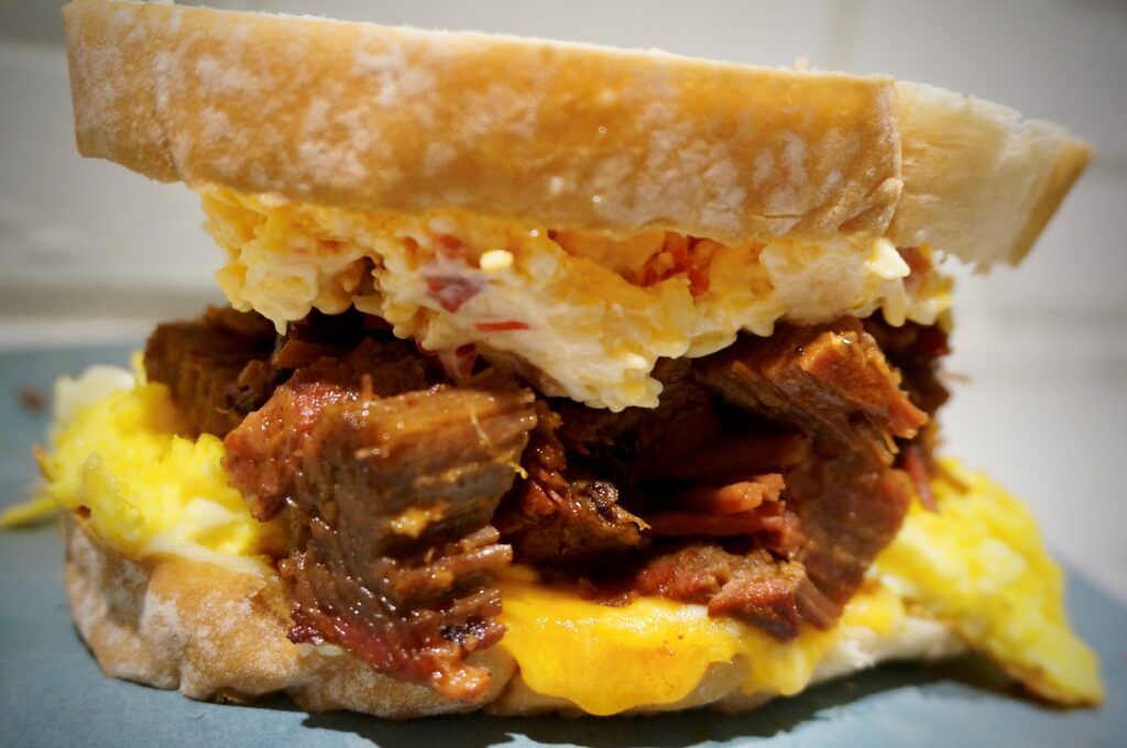 Eggs, smoked brisket and cheese with artisan bread breakfast sandwich