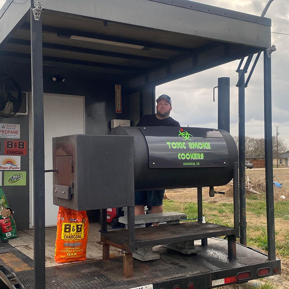 Team B&B pitmaster Dwain Booher,standing behind a black smoker grill