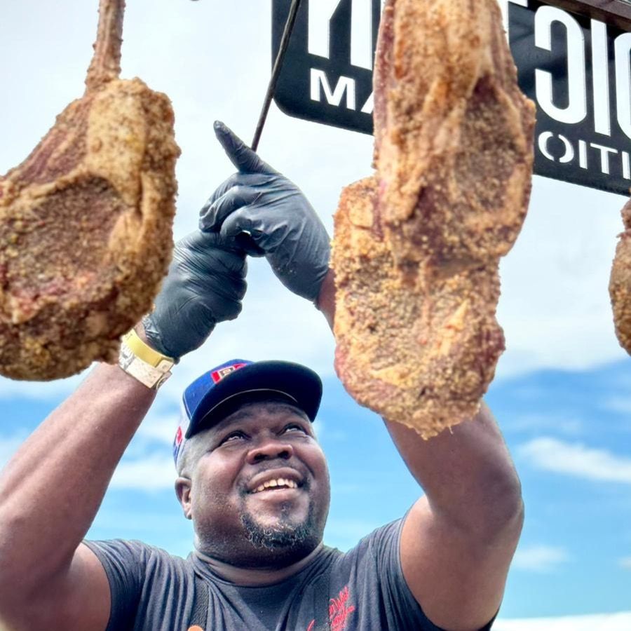 B&B Ambassador and Pitmaster Mark Lambert is holding a trophy on stage at a BBQ competition