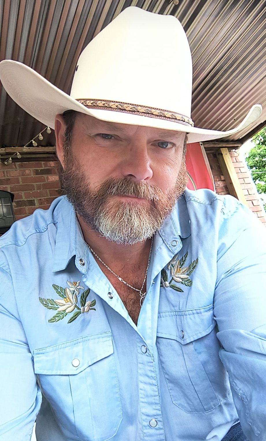 Team B&B pitmaster Jason perrigin in a white cowboy hat and blue shirt