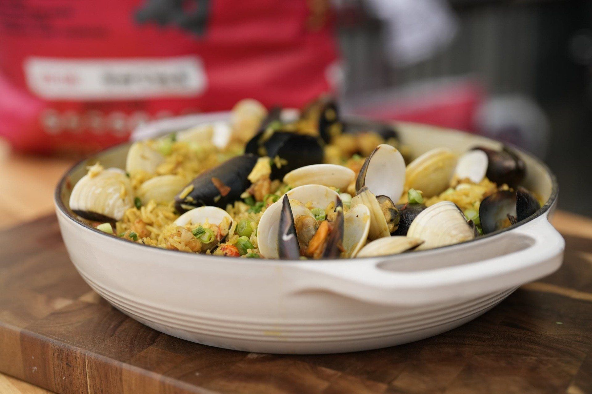 Grilled seafood paella in a white bowl