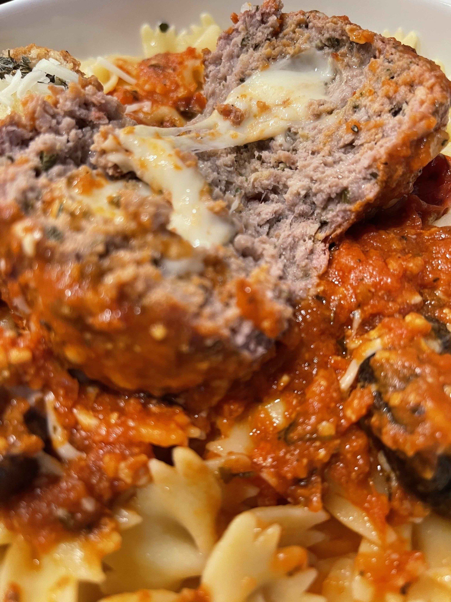 Close up cross section of a grilled stuffed meatball