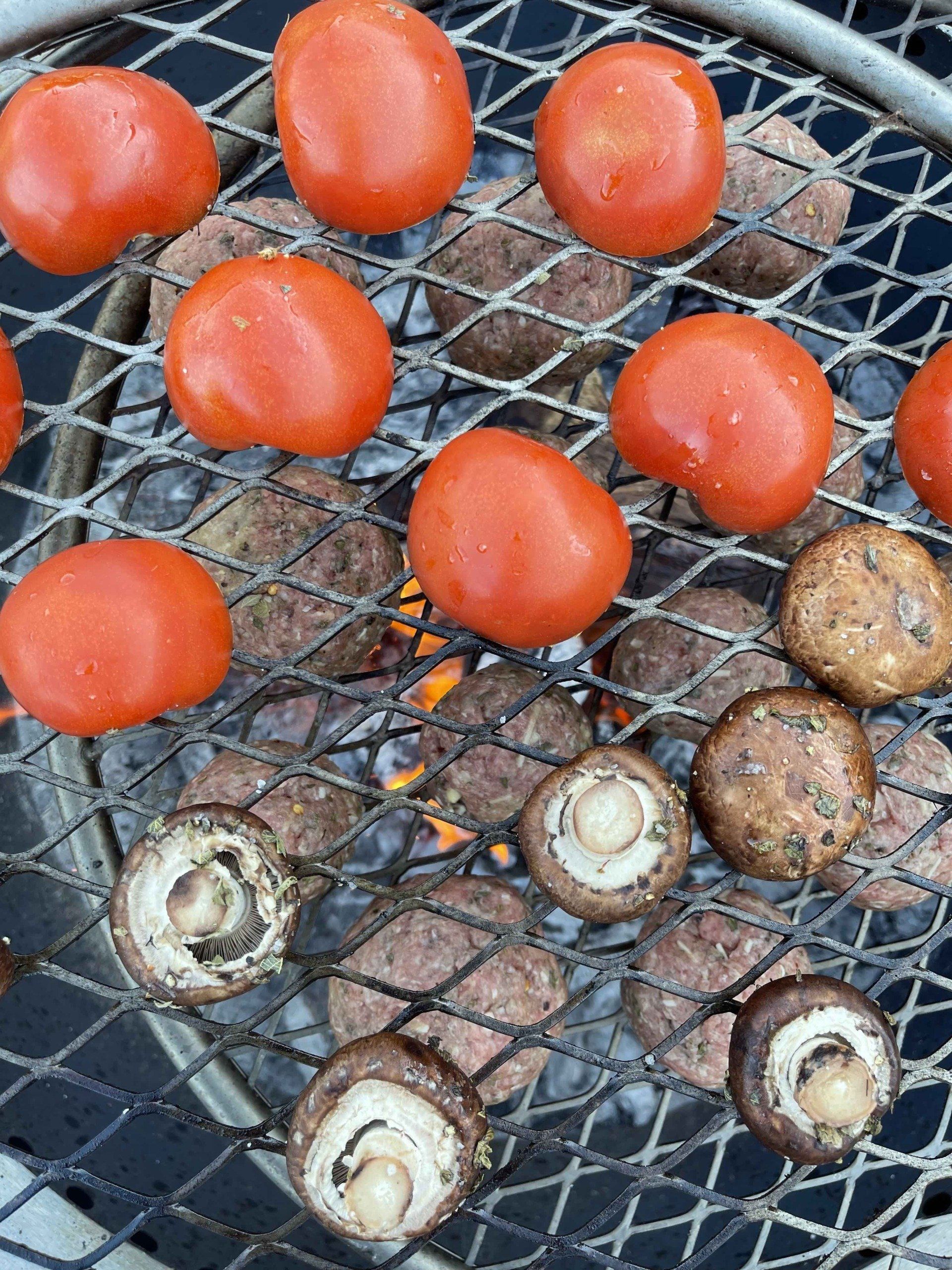 Tomatoes, Mushrooms, and stuffed meatballs cooking on the grill