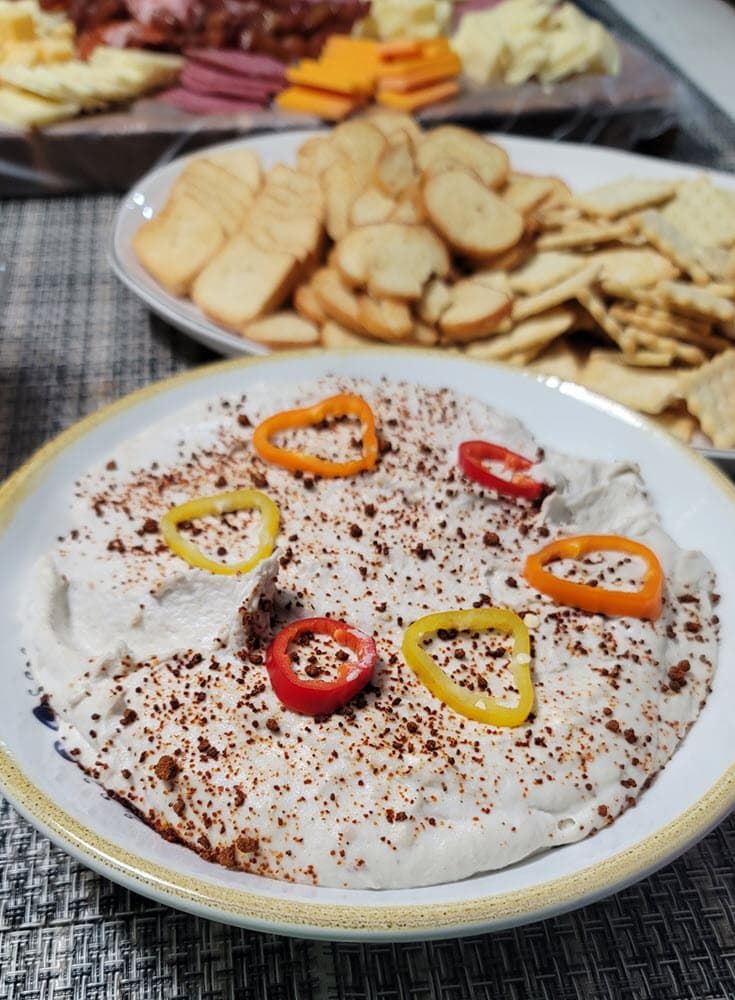 Smoked fish dip in a bowl garnished with spices and peppers