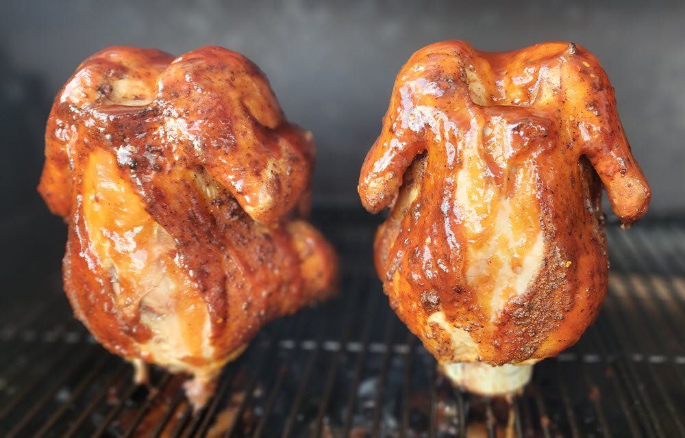2 whole seasoned chickens smoking on the grill