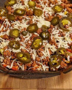 Closeup of nachos with cheese and jalapenos in a pan