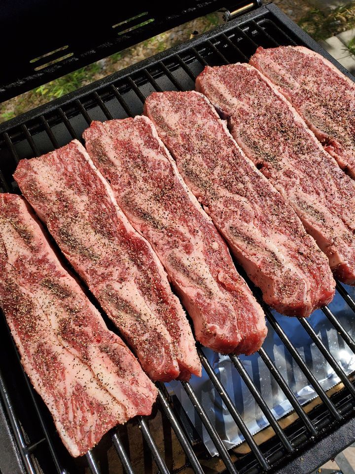 raw seasoned short ribs on a grill