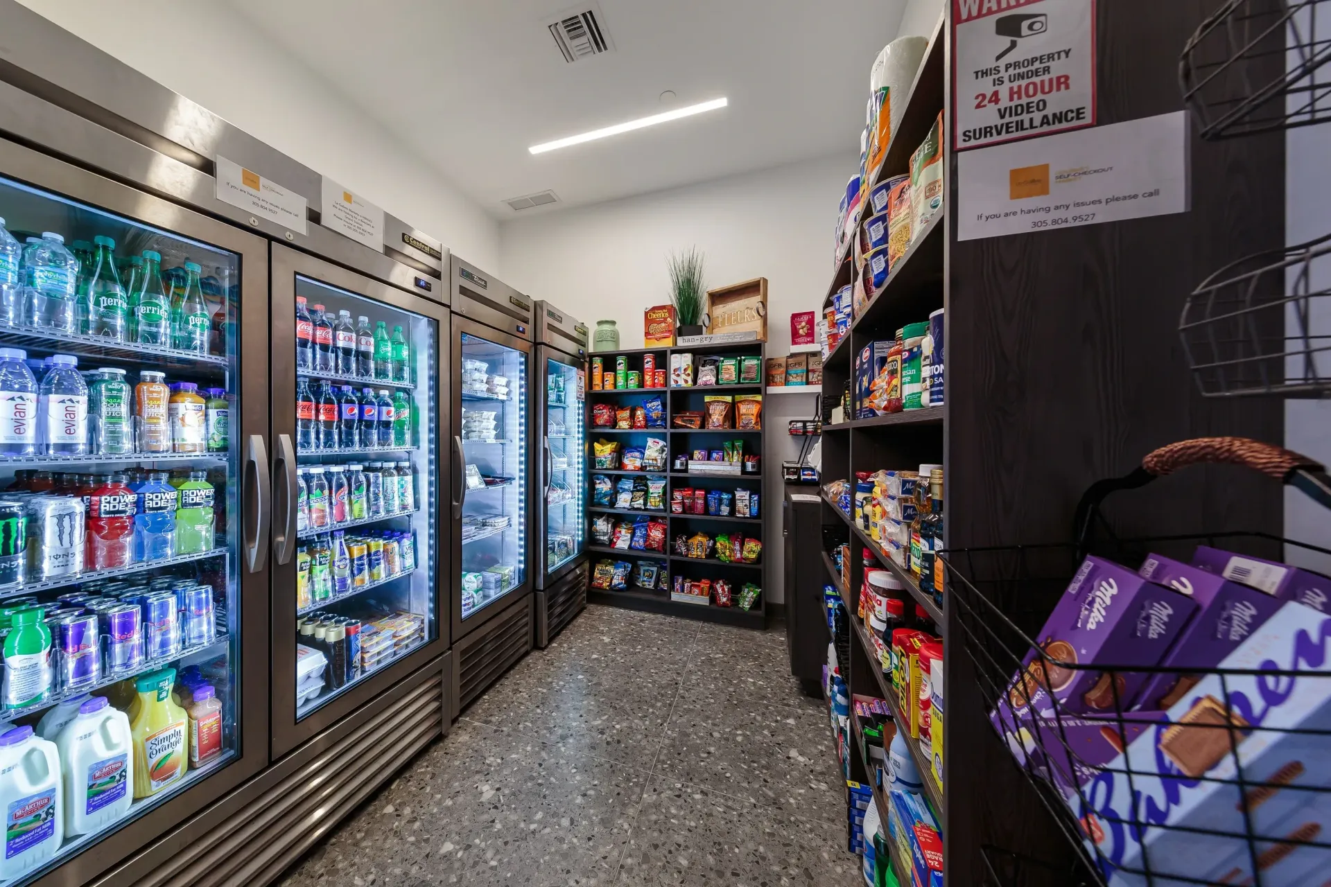 Interior of on-site convenience market with glass-door refrigerators and snack shelves.