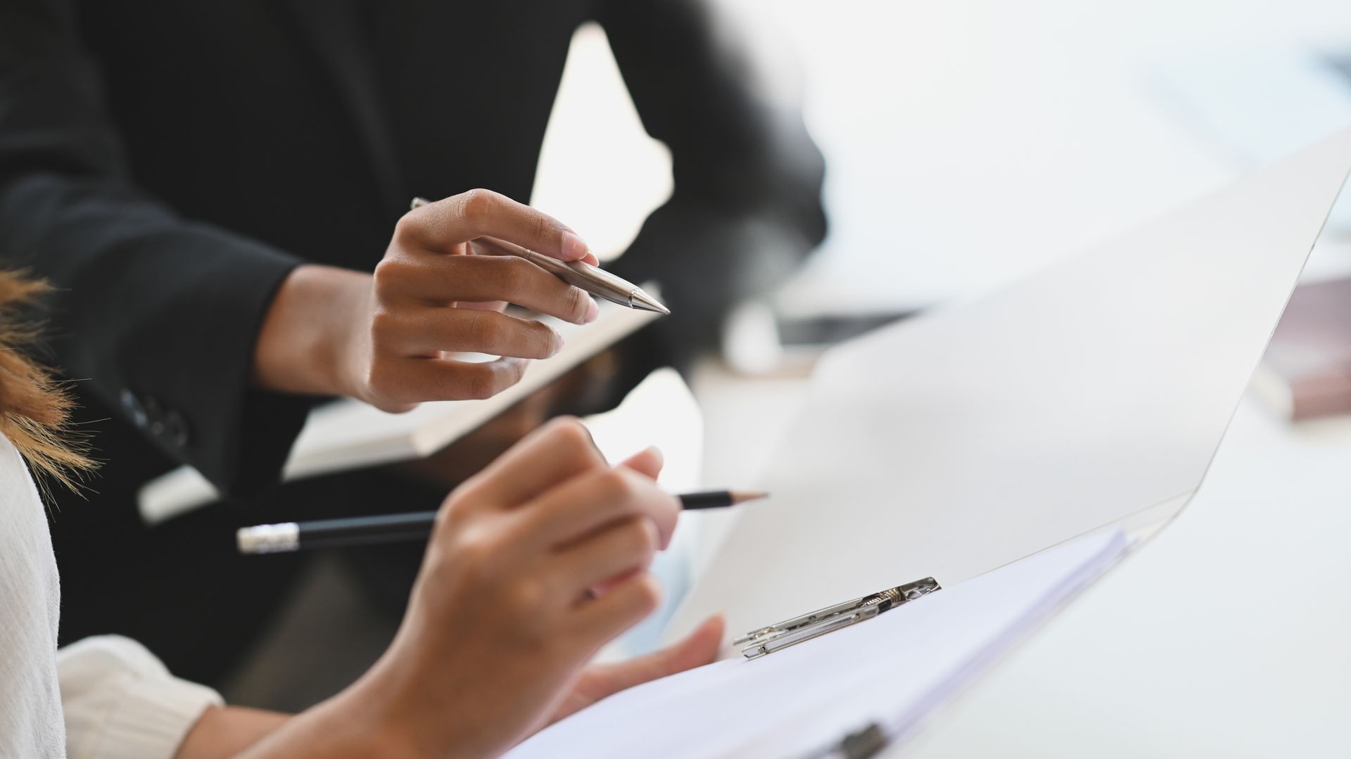 A group of people are sitting at a table looking at a piece of paper.
