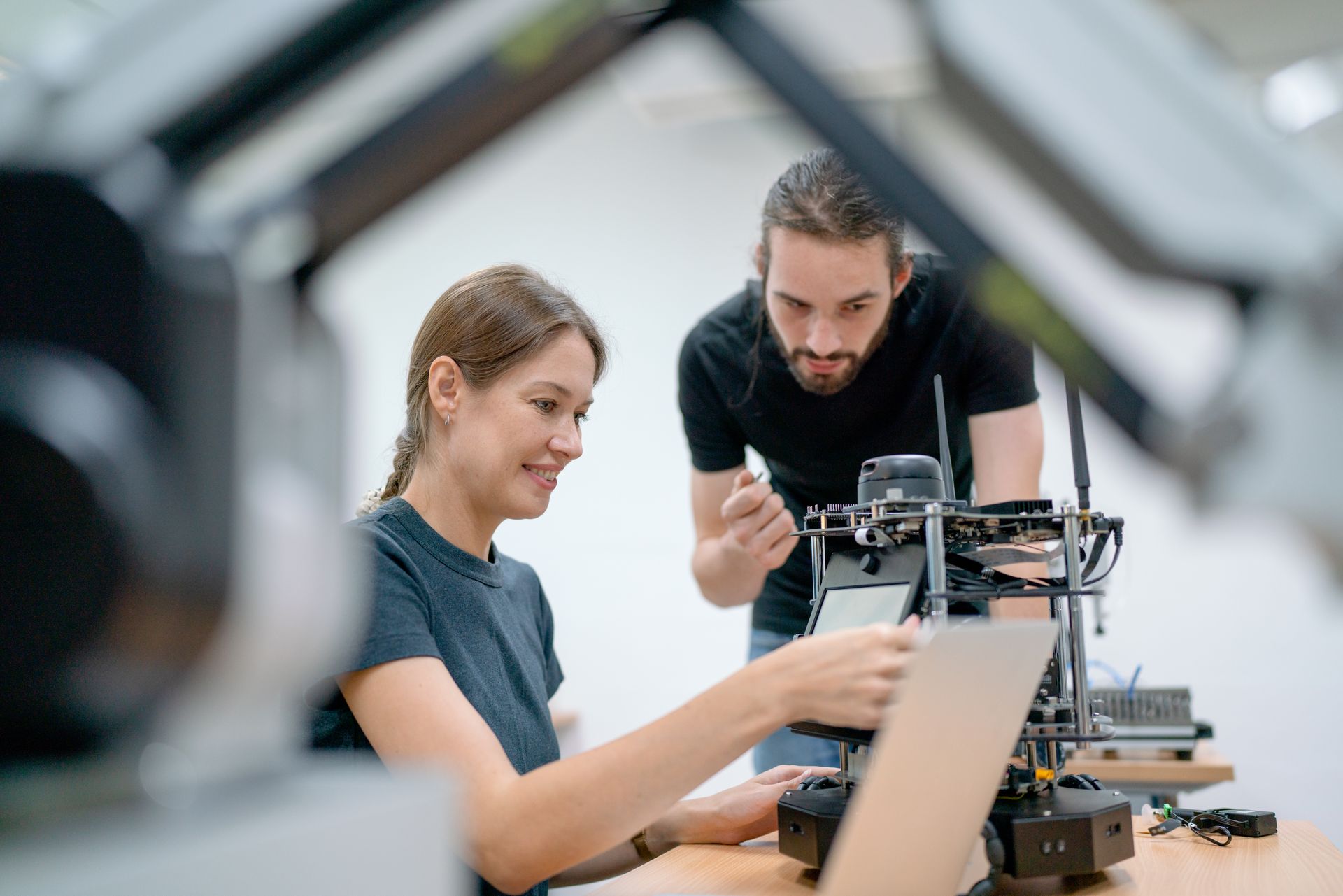 A man and a woman are working on a 3d printer.