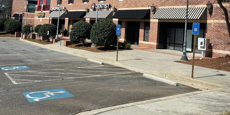 Accessible parking spaces in front of brick storefronts with striped awnings