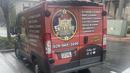 Red food truck with large menu graphics parked on a city street near a curb.