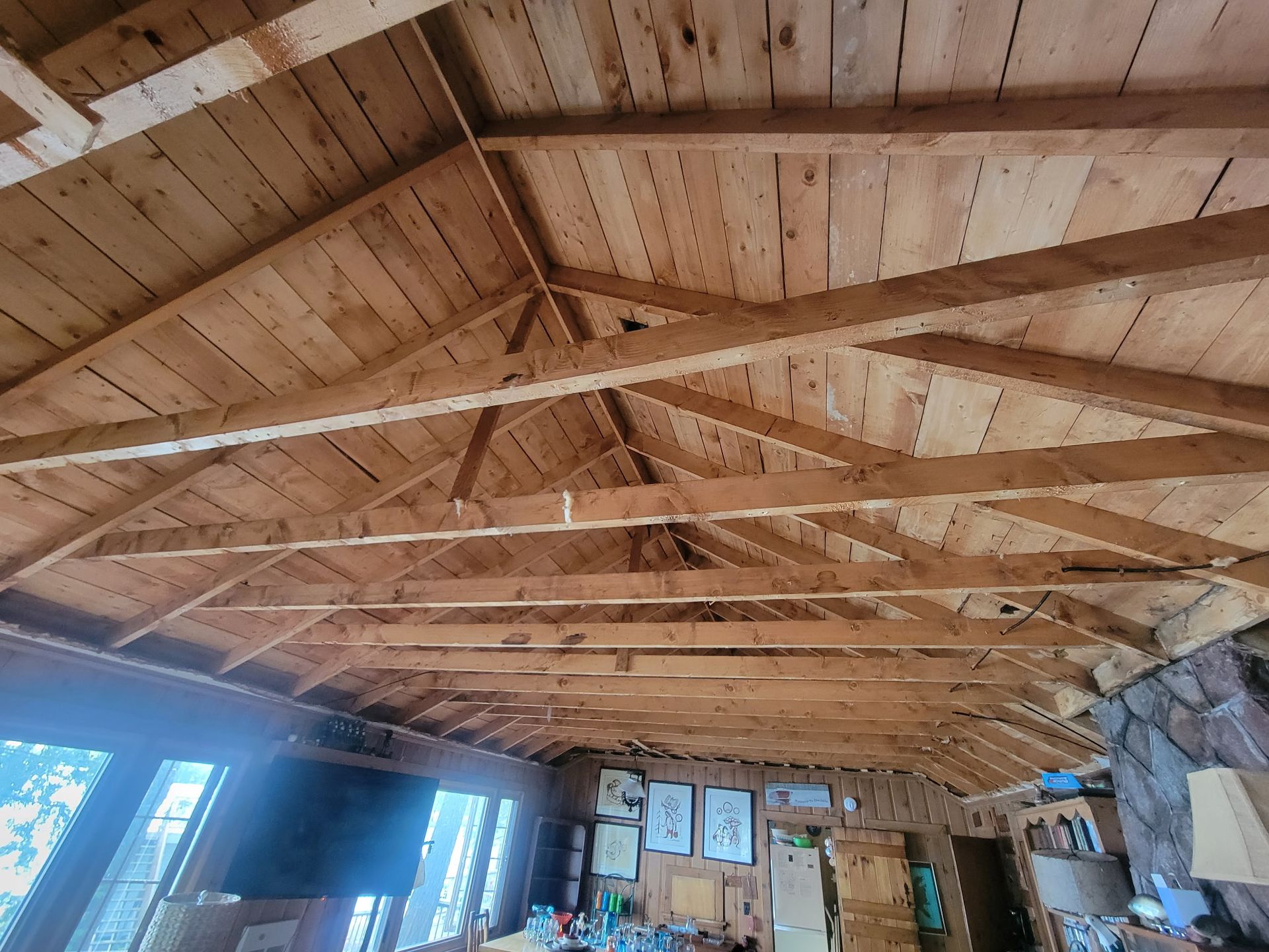 Wooden vaulted ceiling in a rustic lodge with exposed beams and stone walls