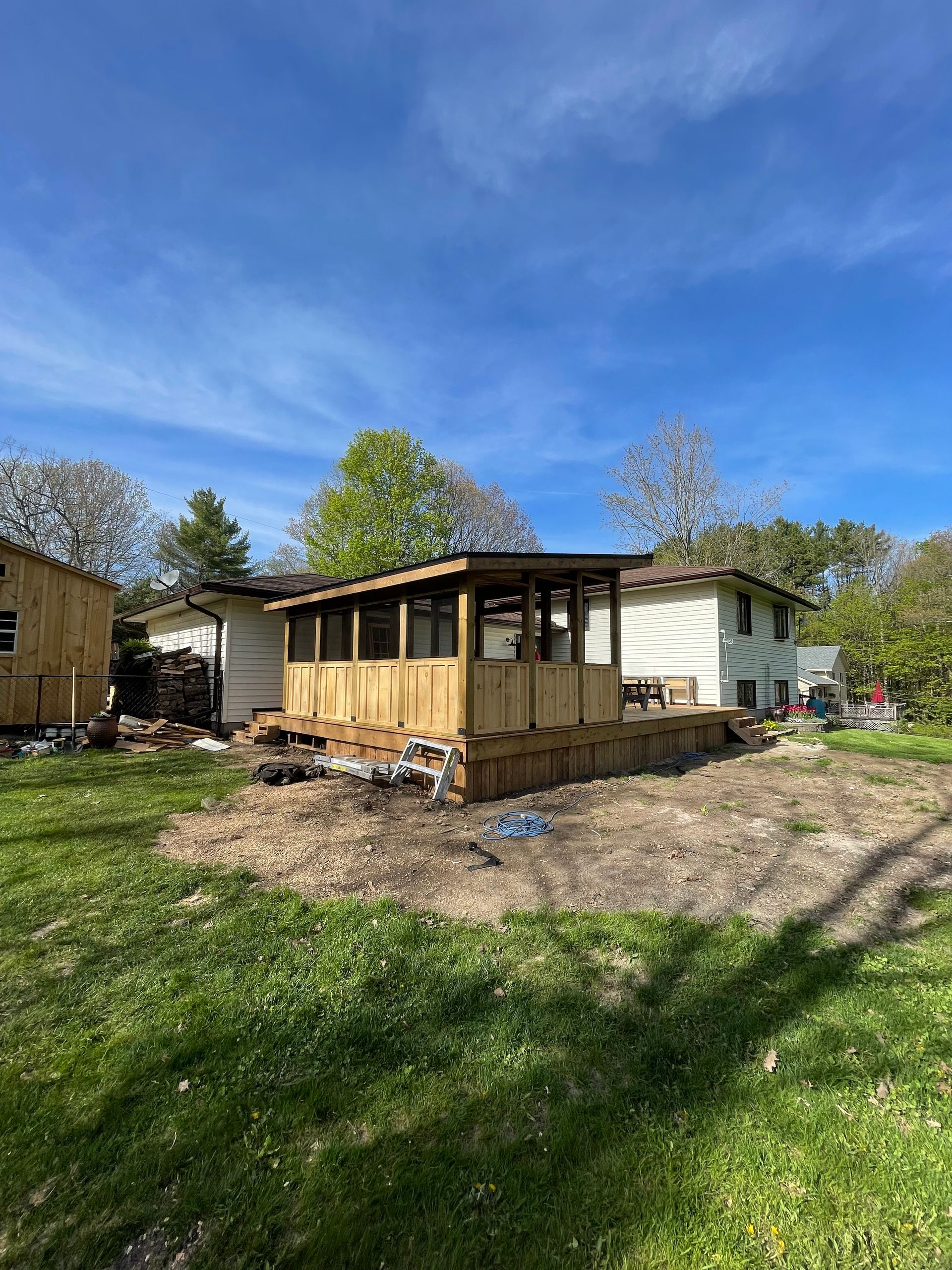 Wooden deck and enclosed structure under construction in a yard.