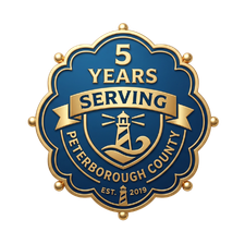 Blue and gold badge reading “5 Years Serving Peterborough County” with a lighthouse and “Est. 2019”