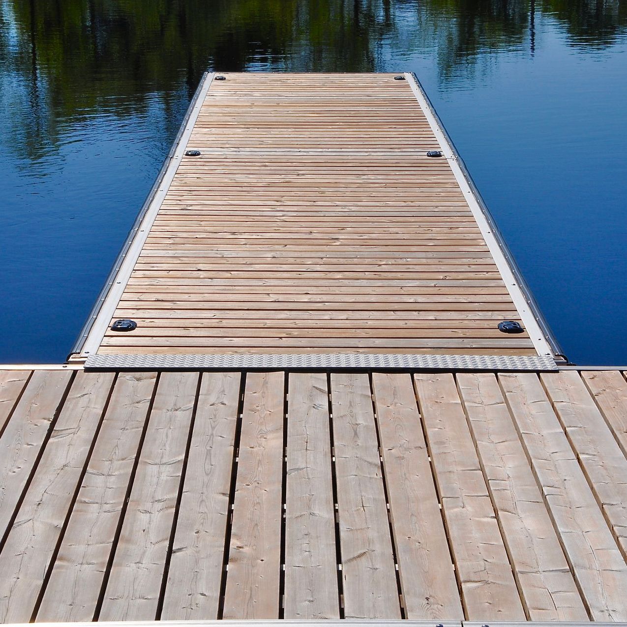 Wooden dock extending over blue water.