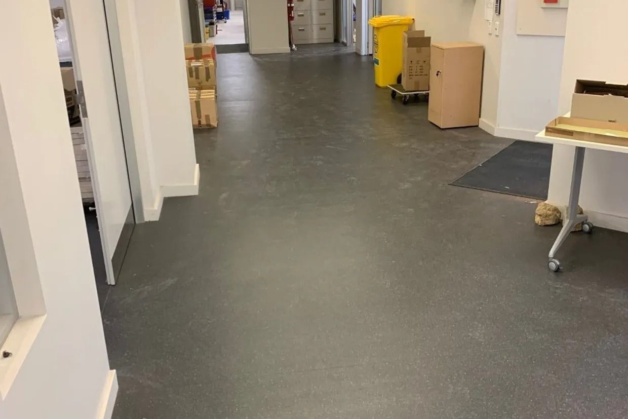 Long Hallway With Grey Flooring, White Walls, and Various Objects — Ozwide Flooring In Ciccone, NT