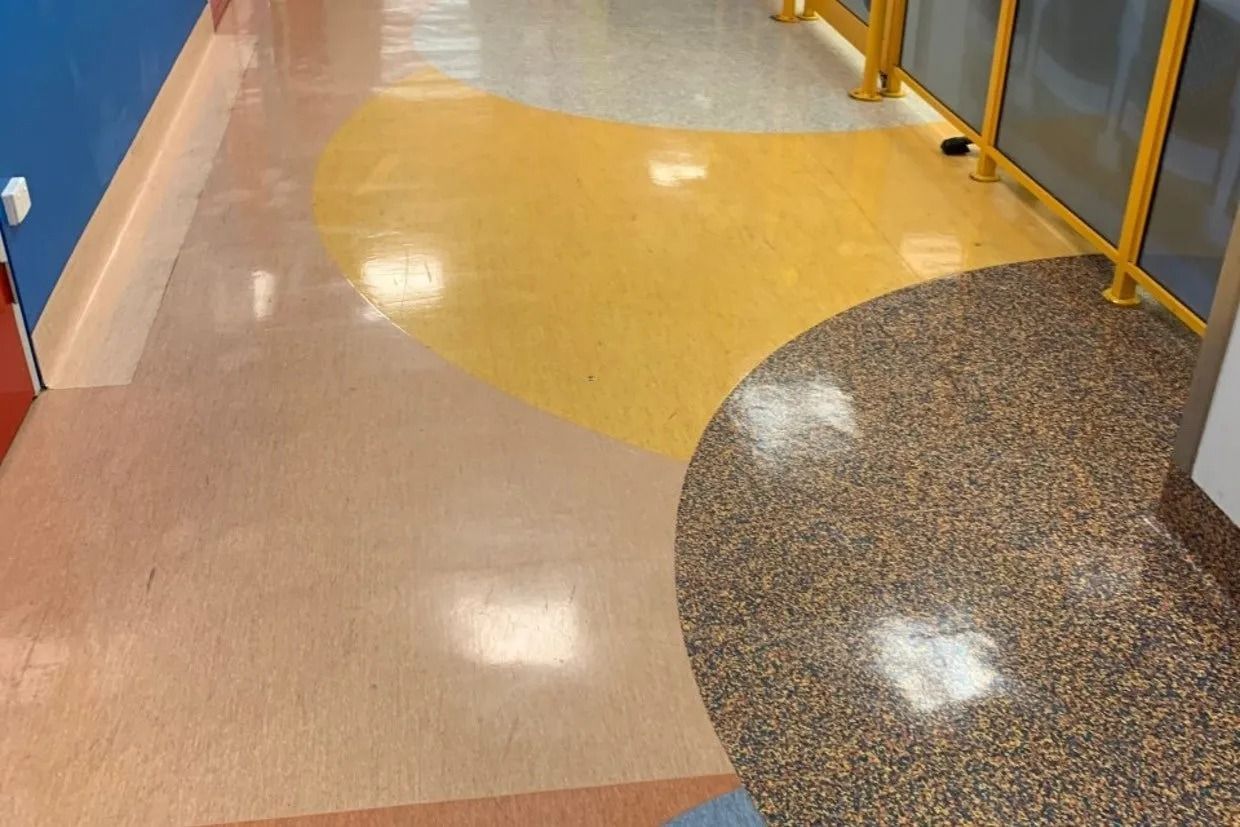 Hallway With Colourful Flooring; Tan, Yellow, and Speckled Brown Sections — Ozwide Flooring In Ciccone, NT