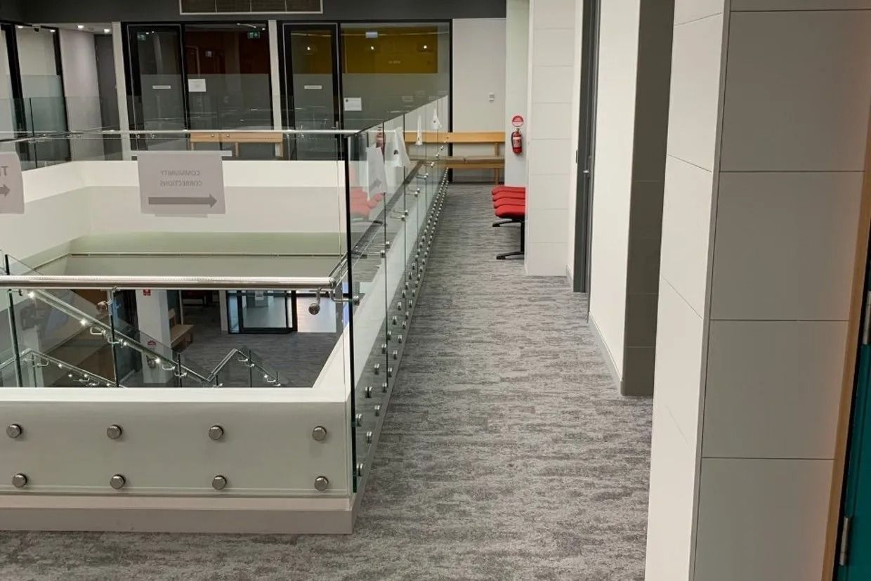 Interior View of a Modern Building With a Glass Railing Overlooking a Lower Level — Ozwide Flooring In Ciccone, NT